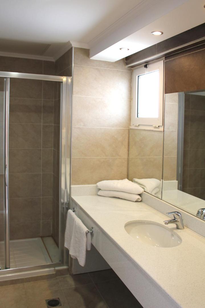 Mūsdienīga Sea Melody Beach Hotel Apartments vannas istaba ar dušas kabīni, plašu spoguli un akmens virsmu