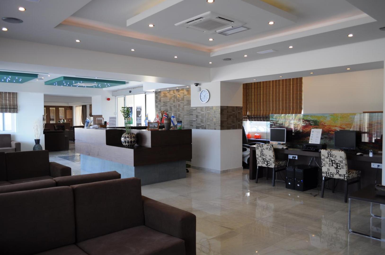 Sea Melody Beach Hotel Apartments modernais vestibils ar recepcijas leti, atpūtas dīvāniem un datoru zonu viesiem.