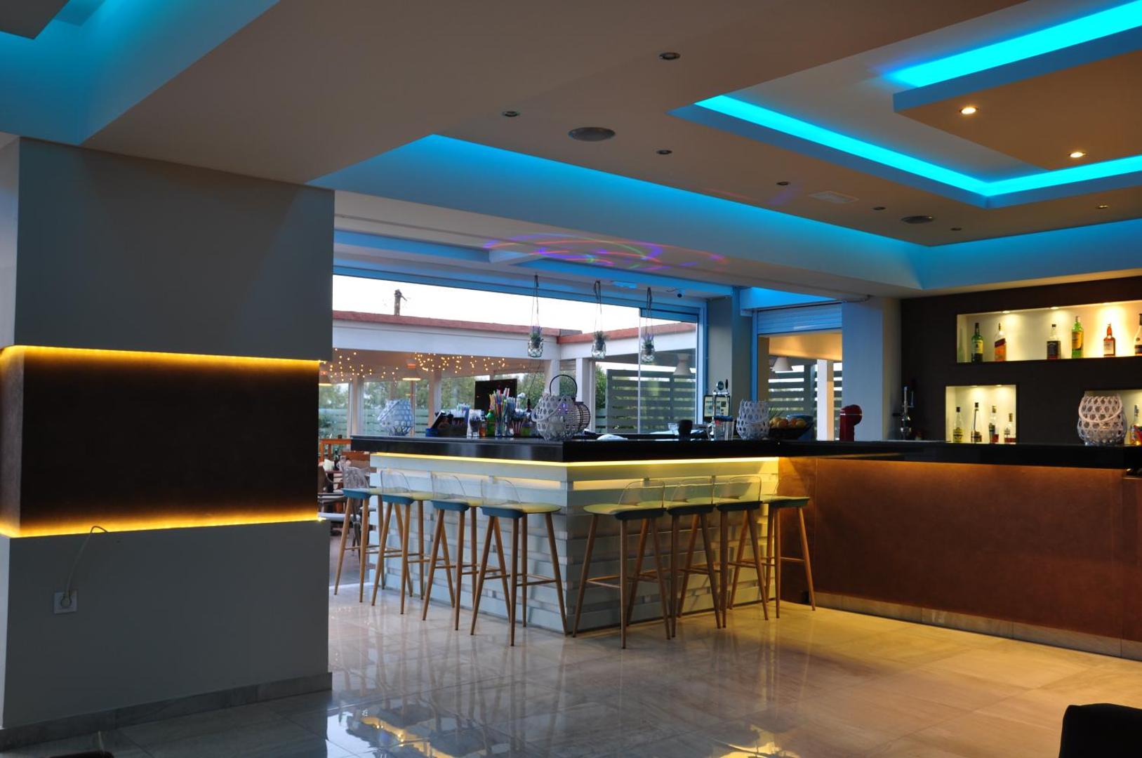 Sea Melody Beach Hotel Apartments iekštelpu bāra lete ar augstajiem krēsliem un dekoratīvu apgaismojumu Rodas kūrortā.