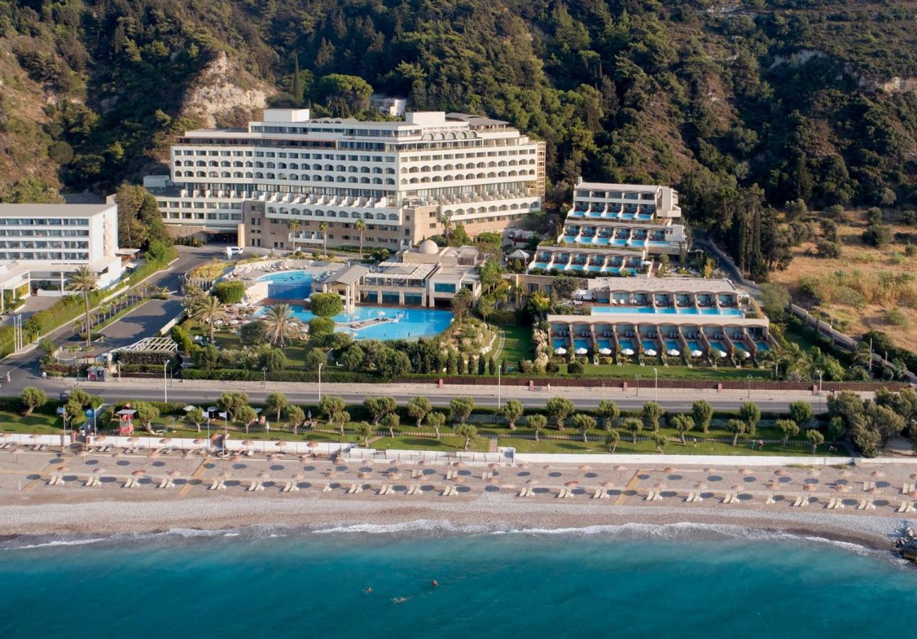 Amus Hotel & Spa panorāmas skats no putna lidojuma Rodas piekrastē — viesnīcas ēka, baseini un privātā pludmale pie zilās jūras