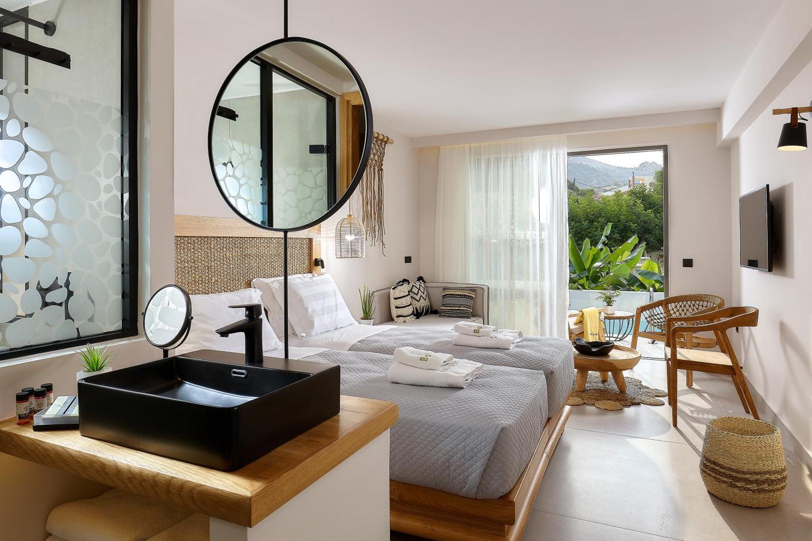 Bali Star Resort Hotel gaišs numurs ar atvērtā plānojuma vannas istabu, melnu izlietni un izeju uz terasi Bali kūrortā