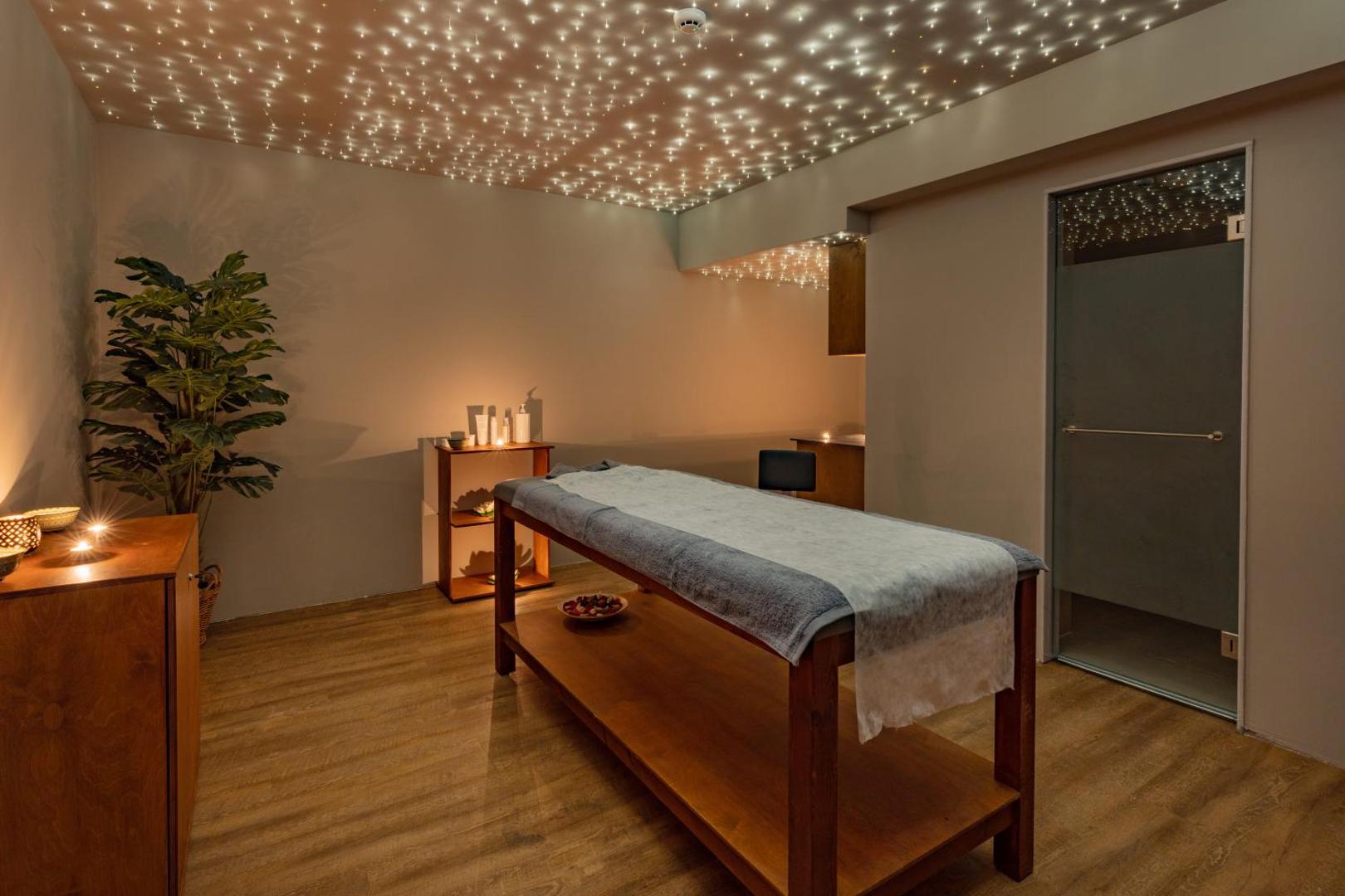 Minos Ambassador Suites & Spa spa centra masāžas telpa ar zvaigžņotām debesīm līdzīgu apgaismojumu un relaksējošu atmosfēru