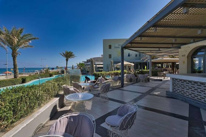 Aegean Pearl āra terase ar modernām mēbelēm, skatu uz jūru un palmu dārzu Retimno piekrastē, Krētā