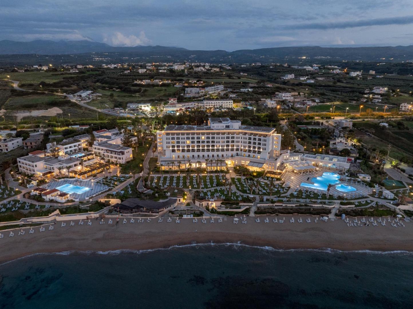 Creta Star Hotel panorāmas skats krēslas stundā — viesnīcas fasāde, baseinu zonas un tieša piekļuve jūrai Retimno reģionā
