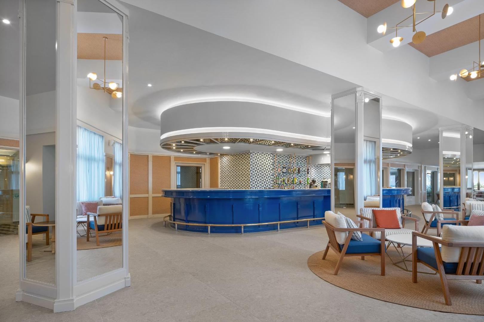 Creta Star Hotel modernais lobby bārs ar zilu leti, stilīgiem krēsliem un spoguļu elementiem Krētā