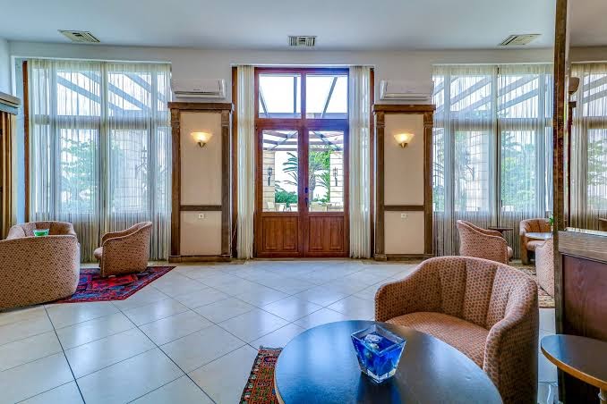Creta Star Hotel plašā lobby atpūtas zona ar ērtiem atpūtas krēsliem, lieliem logiem un klasisku interjeru Krētas piekrastē