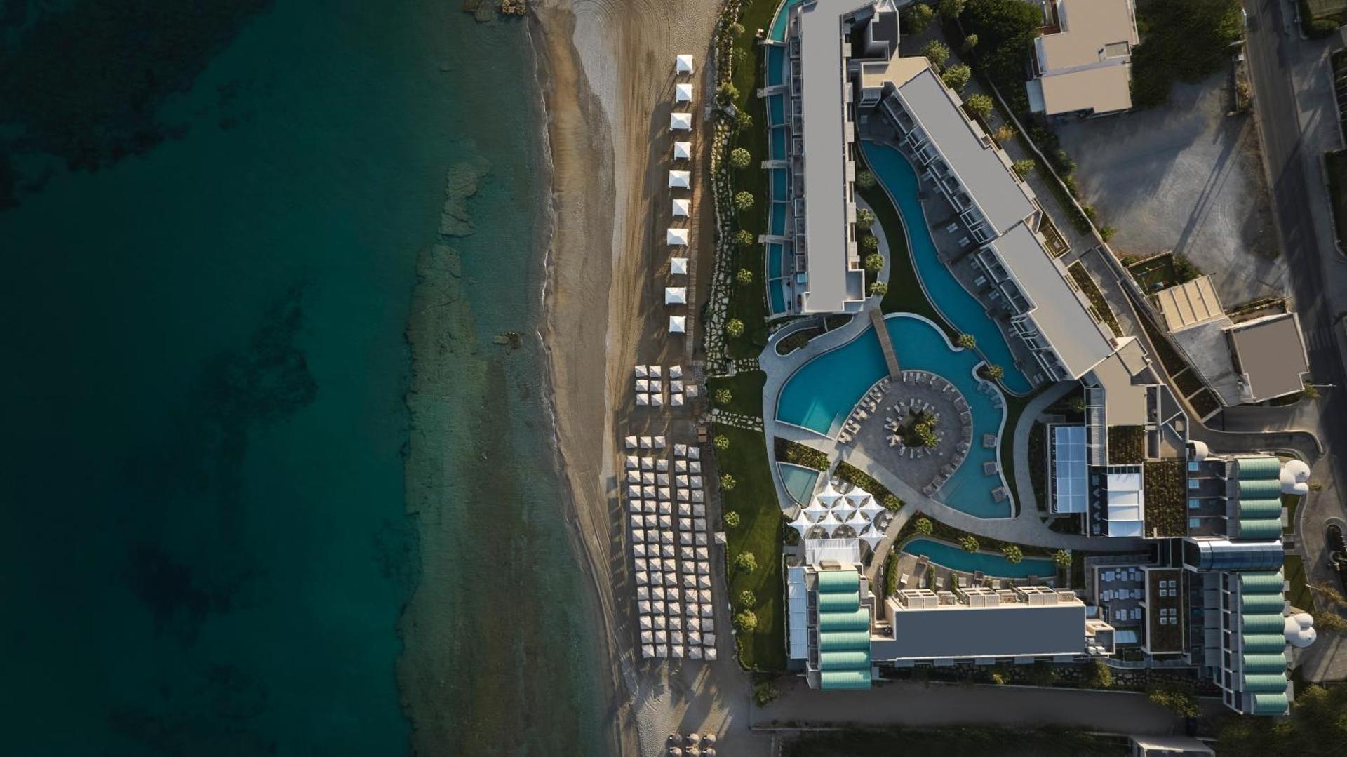 Amira Luxury Resort teritorijas aerofoto — tieša piekļuve pludmalei, vairāki baseini un viesnīcas korpusi Krētas piekrastē