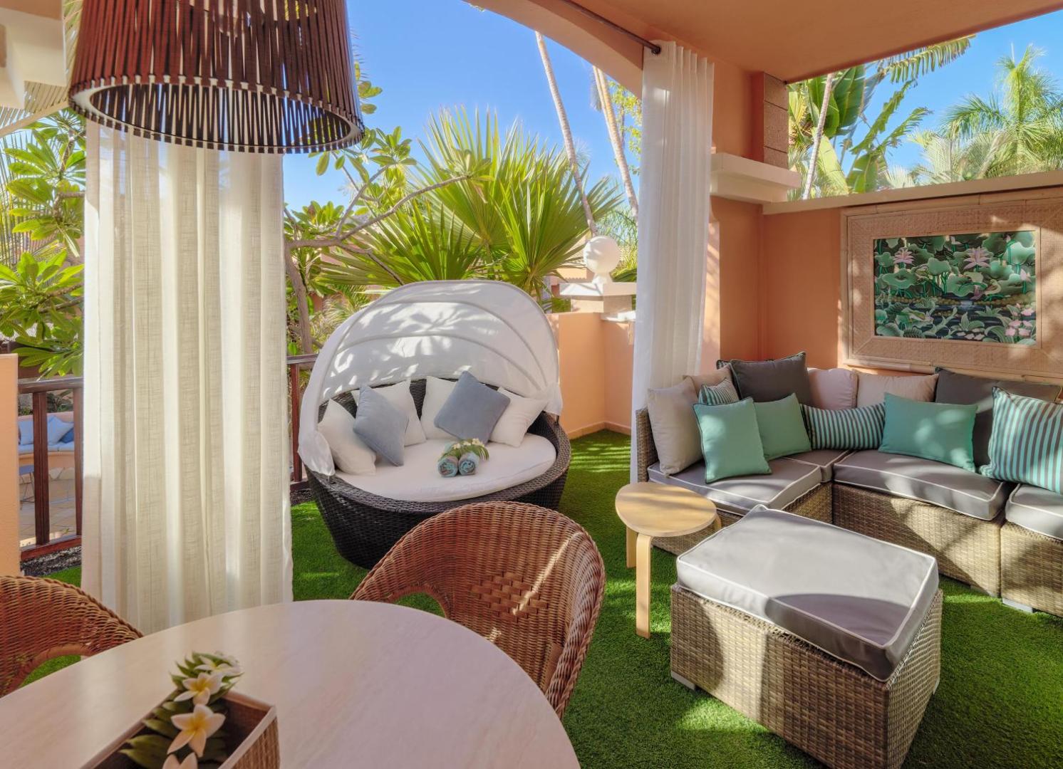 Green Garden Eco Resort labiekārtota numura terase ar atpūtas dīvāniem un tropu augiem Tenerifē — mēbelēta āra zona atpūtai