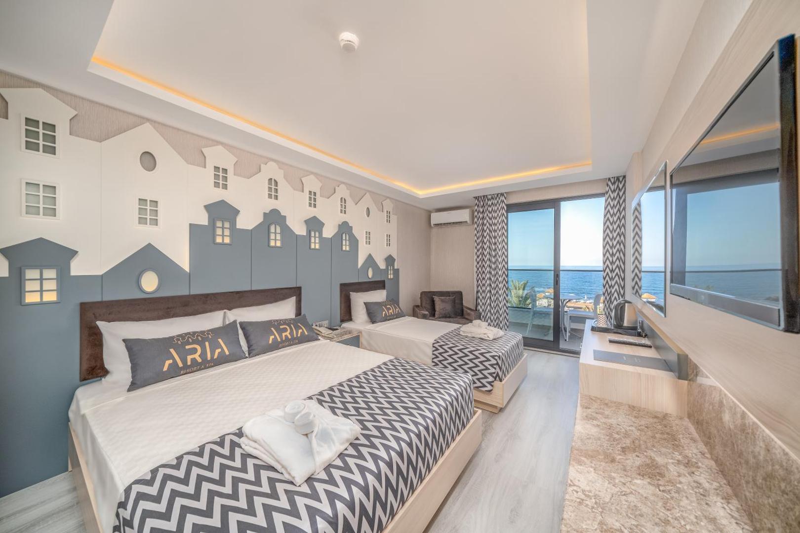 Aria Resort & Spa numurs ar divām gultām, dekoratīvu sienas panno un balkonu, no kura paveras skats uz Vidusjūru