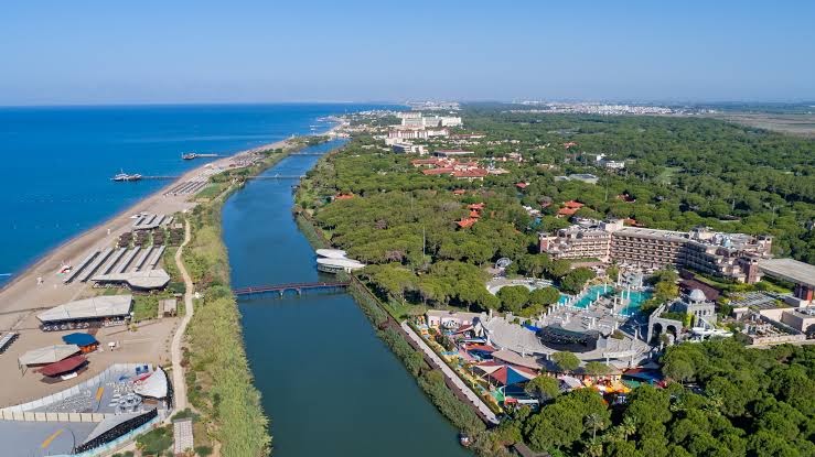 Xanadu Resort Hotel panorāmas skats uz Vidusjūras piekrasti, upi un plašo viesnīcas teritoriju Belekas reģionā, Turcijā