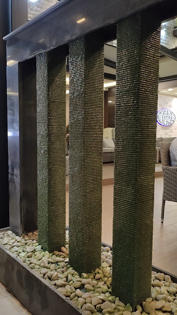 ACD Wellness & Spa viesnīcas vestibila interjera elements ar dekoratīvu ūdens sienu un oļiem, radot mierīgu atmosfēru viesiem