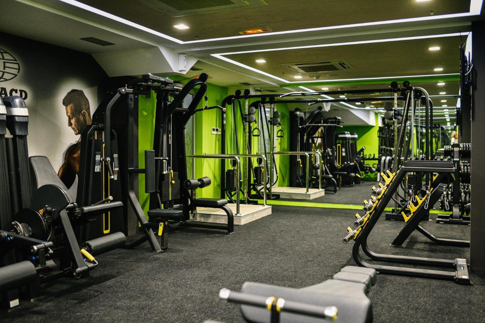 Plašs ACD Wellness & Spa sporta zāles skats ar modernu aprīkojumu, spoguļu sienu un profesionāliem trenažieriem