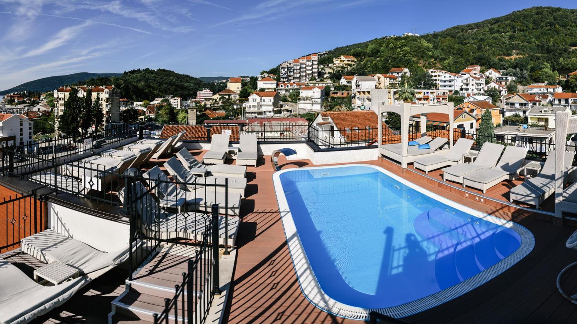 Viesnīcas ACD Wellness & Spa jumta baseins un sauļošanās terase ar skatu uz pilsētu un apkārtējiem kalniem Melnkalnē
