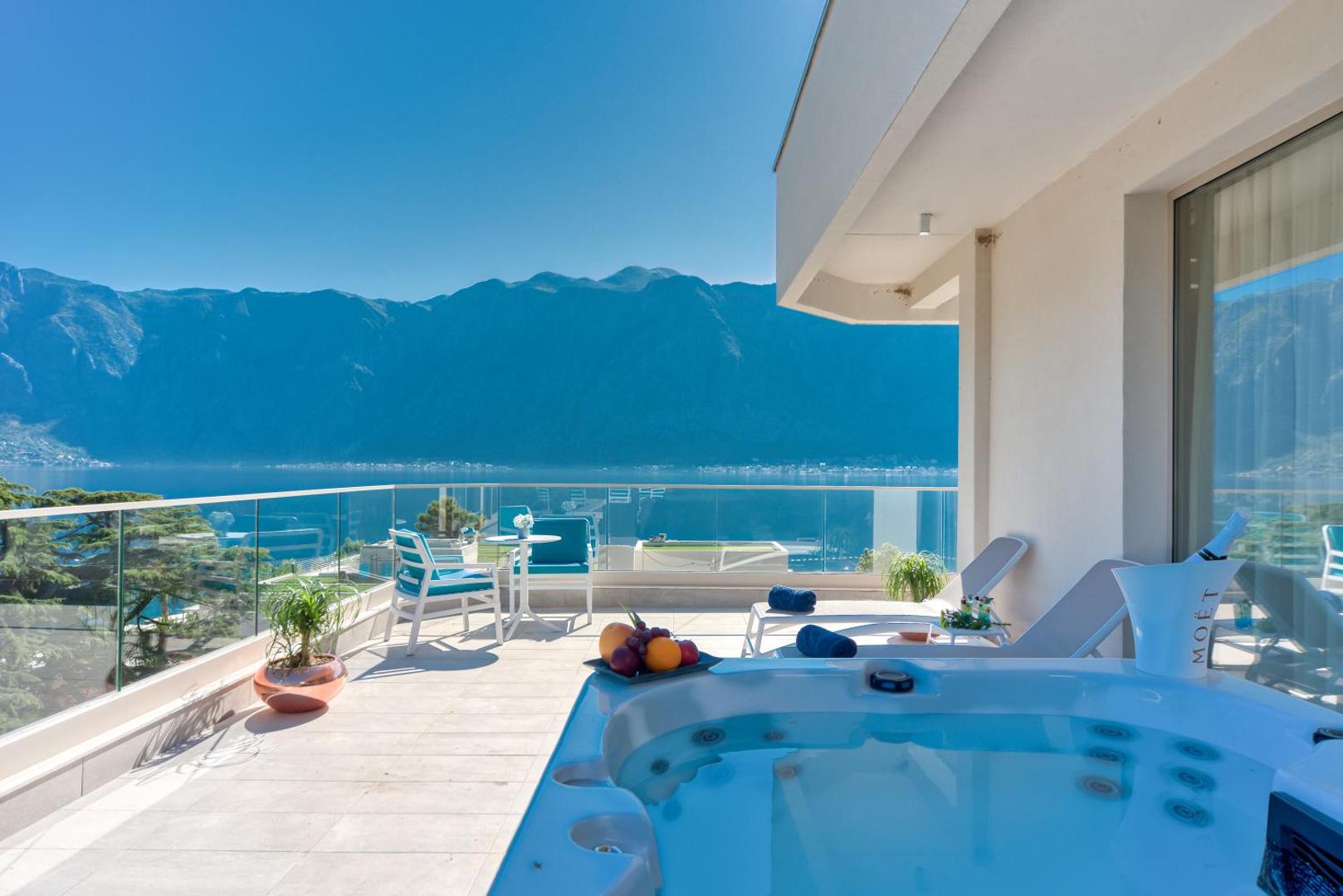 Hyatt Regency Kotor Bay Resort plaša numura terase ar džakuzi, sauļošanās krēsliem un skatu uz Kotoras līci