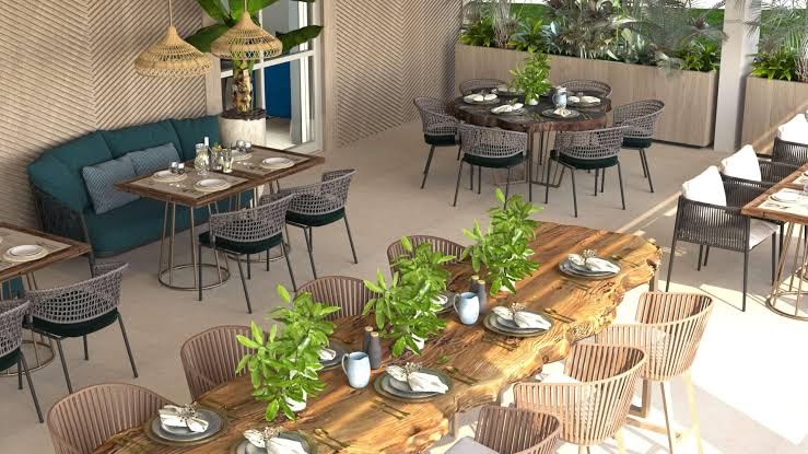 Hyatt Regency Kotor Bay Resort iekštelpu restorāna dizains ar masīvkoka galdiem, pītiem krēsliem un stilīgiem gaismas ķermeņiem