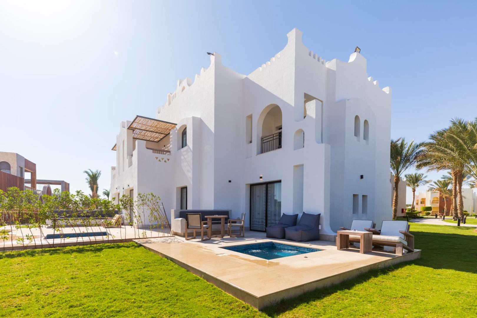 Sunrise Tucana Resort modernā villa ar privātu baseinu un atpūtas zonu zālienā, Hurgadas reģionā, Ēģiptē — balta arhitektūra un palmas.