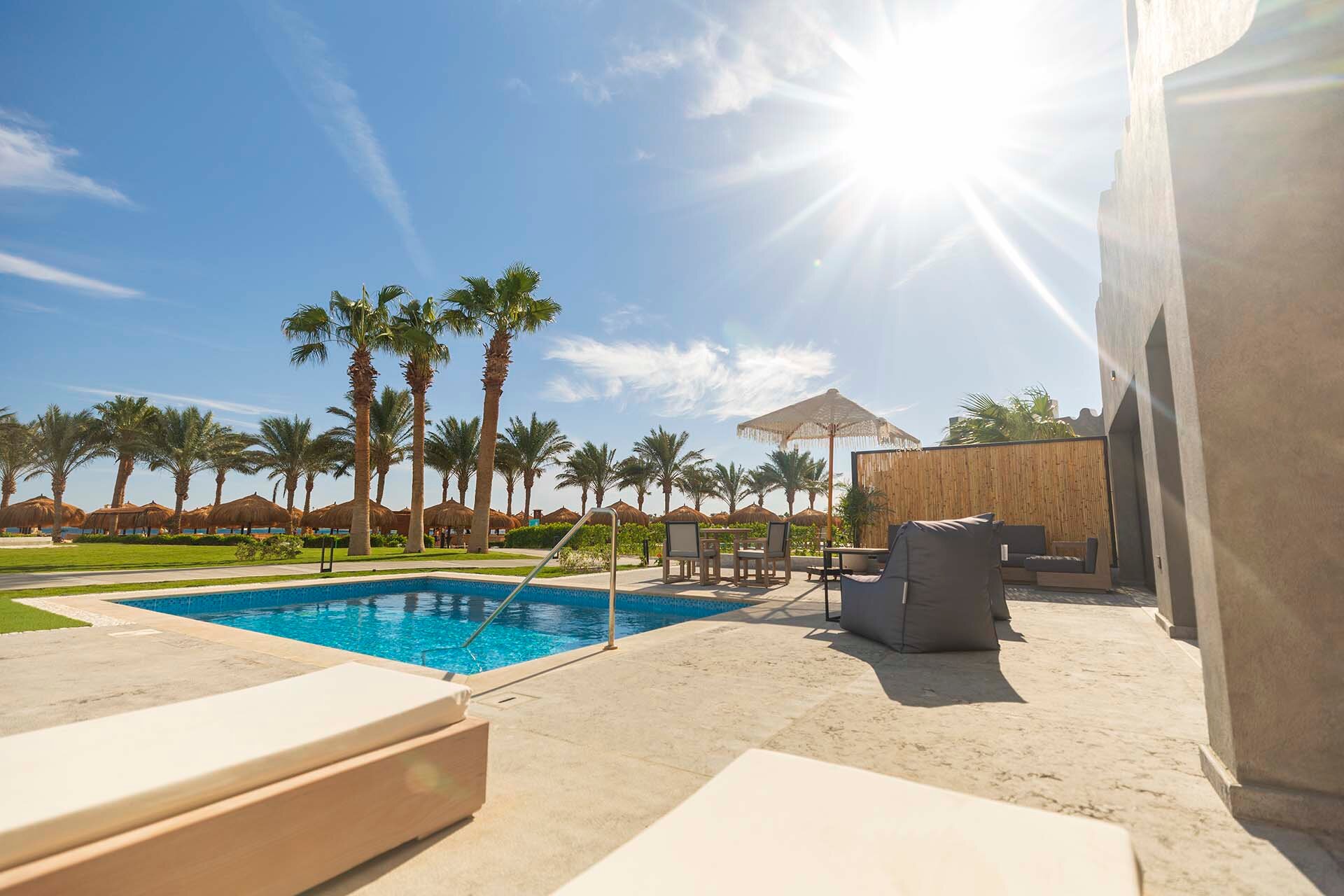 Sunrise Tucana Resort terase ar atpūtas krēsliem un nelielu baseinu, fonā palmas un saulaina debess Makadi Bay.