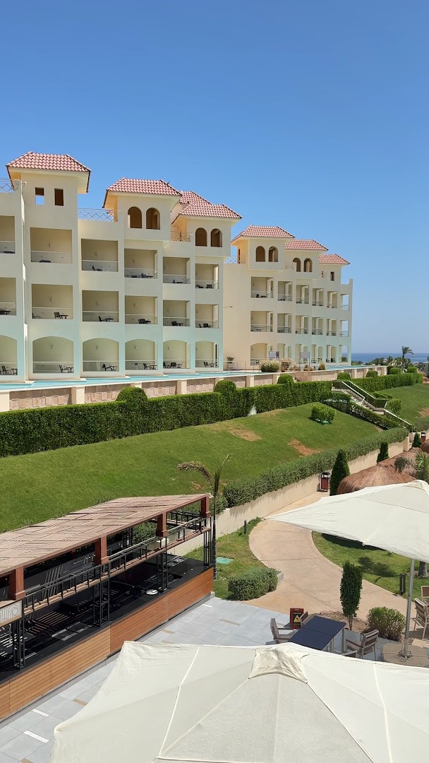 Xanadu Makadi Bay viesnīcas korpusi ar balkoniem, koptu zālienu un āra bāru Makadi līča piekrastē