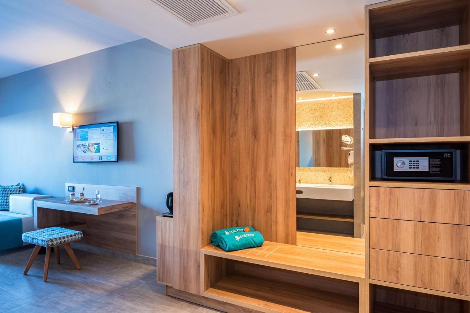 Solimar Aquamarine Resort numura interjers ar koka mēbelēm, iebūvētu seifu, spoguli un skatu uz vannasistabu Hanijas reģionā, Krētā