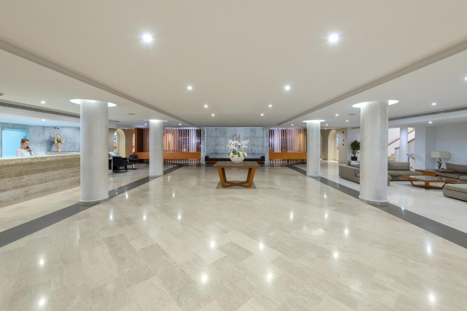 Lindos Royal Resort plašais un gaišais lobby vestibils ar marmora grīdu, modernām kolonnām, atpūtas zonu un viesu uzņemšanas leti