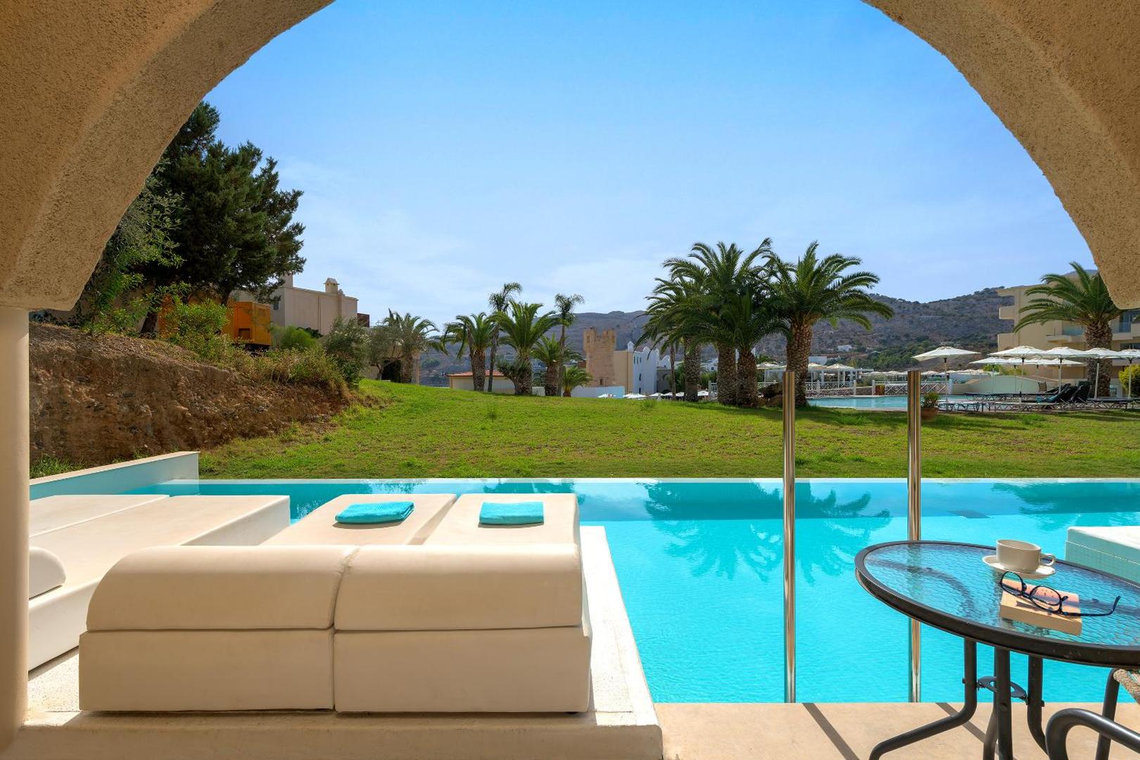 Lindos Royal Resort terase ar privātu baseinu un skatu uz dārzu un palmām — atpūtas zona ar mīkstiem zviļņiem