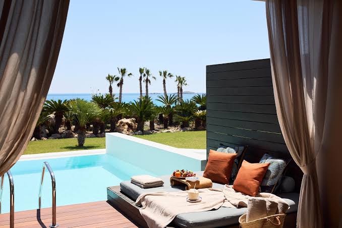 Aquagrand Exclusive Deluxe Resort numurs ar tiešu piekļuvi baseinam Rodas salā — privāta terase ar atpūtas gultu un skatu uz jūru