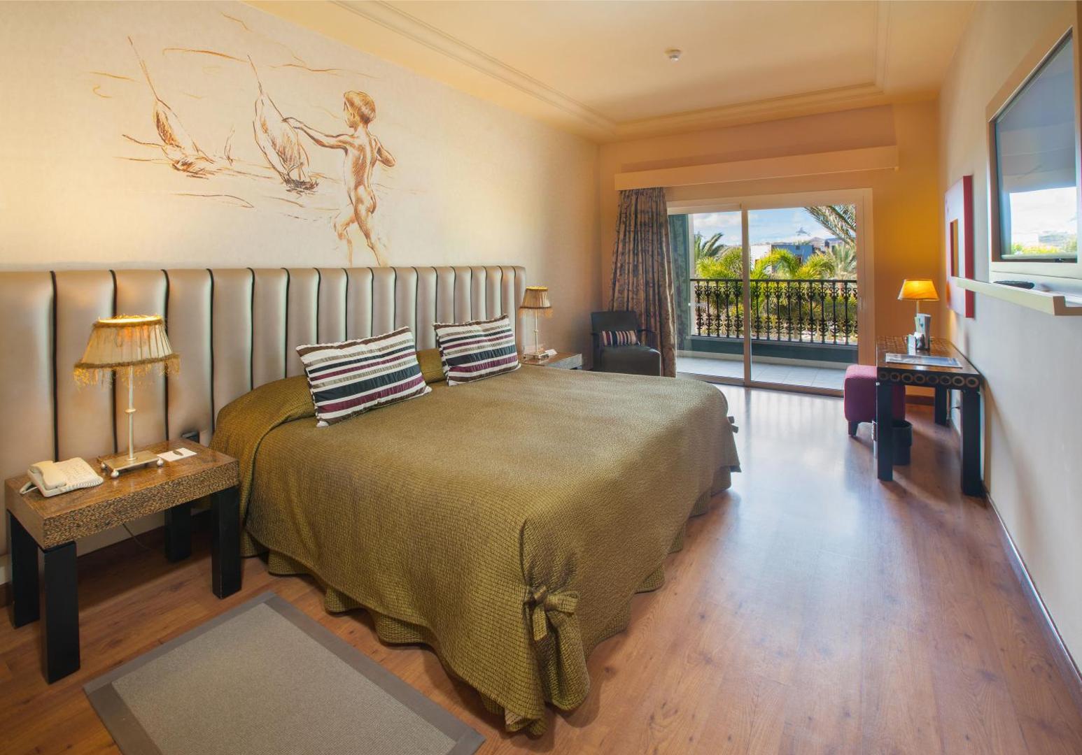 Lopesan Villa del Conde Resort & Thalasso viesnīcas numurs ar lielu gultu, koka grīdu un balkonu Gran-kanārijā