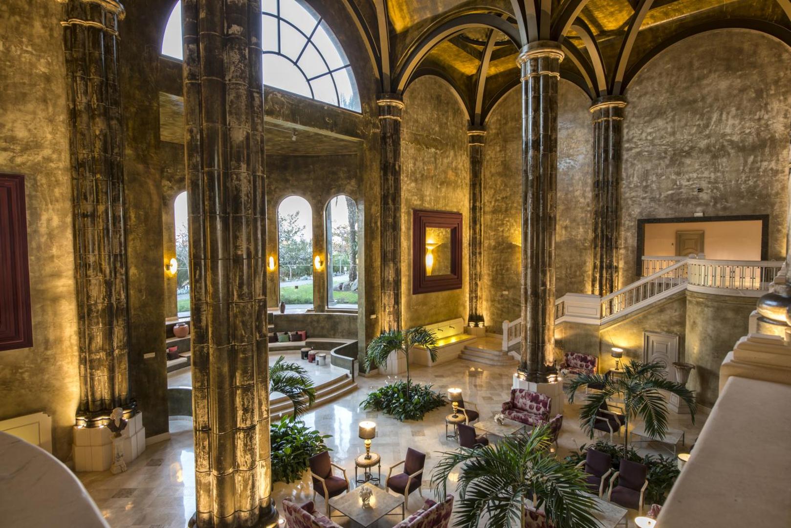 Lopesan Villa del Conde Resort & Thalasso iespaidīgais vestibils ar augstām kolonnām un kupola griestiem, kas atgādina katedrāles arhitektūru