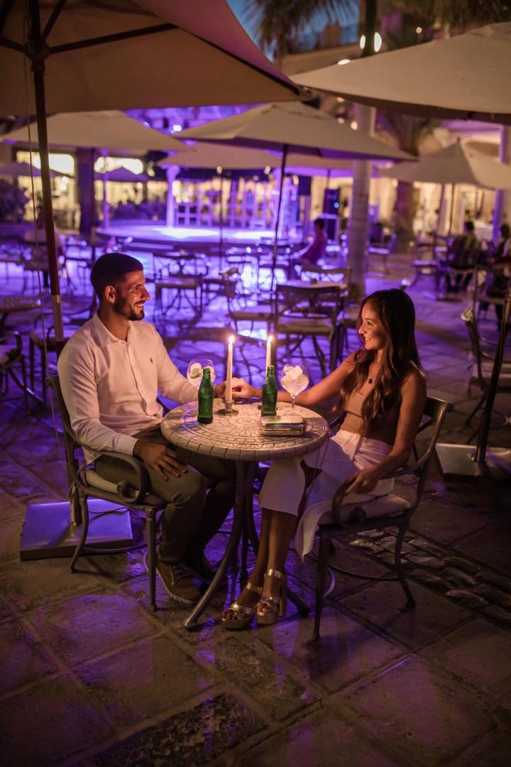 Lopesan Villa del Conde Resort & Thalasso vakara atmosfēra terasē ar pāri pie galdiņa sveču gaismā un violetu apgaismojumu fonā