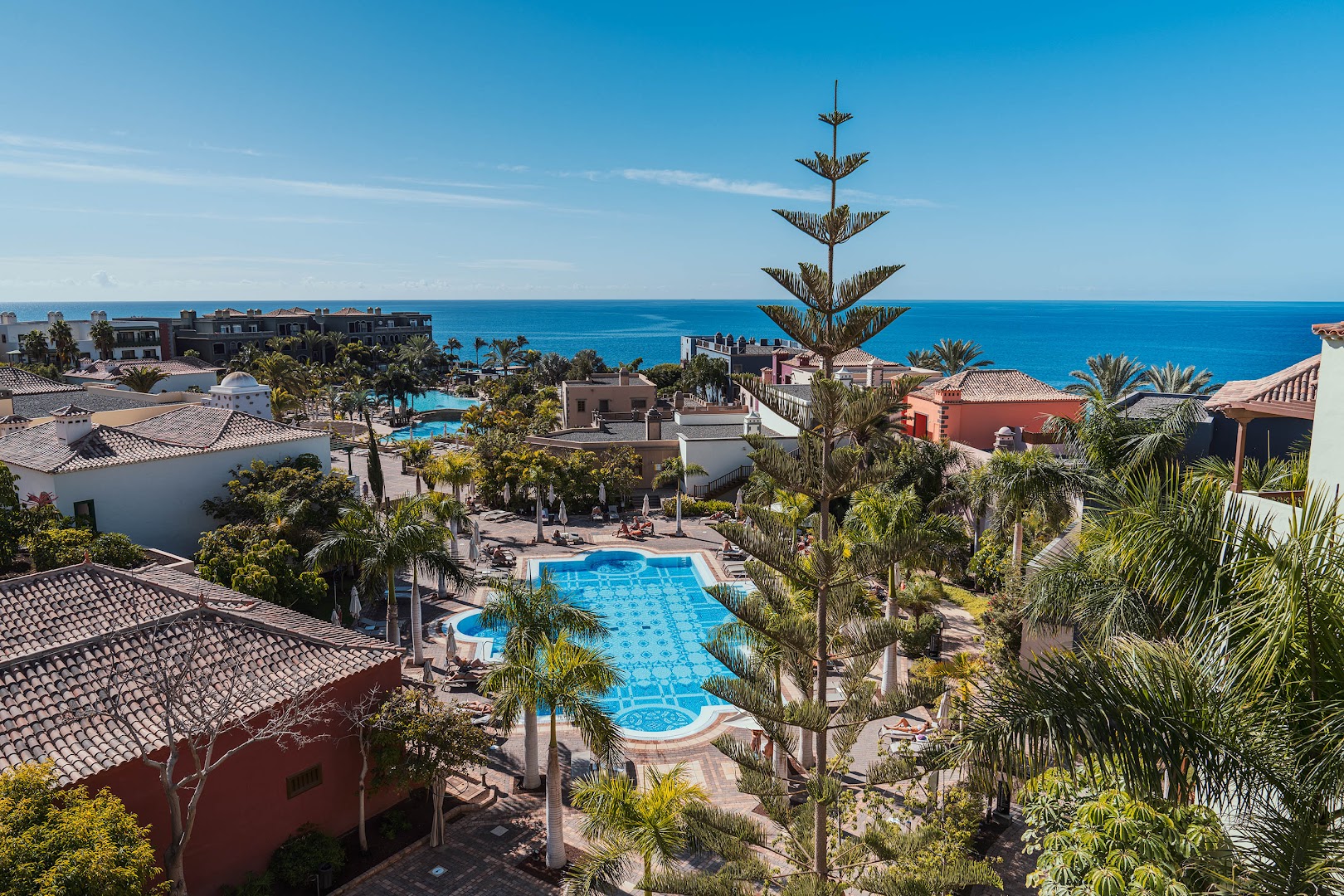 Lopesan Villa del Conde Resort & Thalasso skats no augšas uz āra baseiniem, dārzu un zilo okeānu horizontā Melonerasā, Grankanārijā