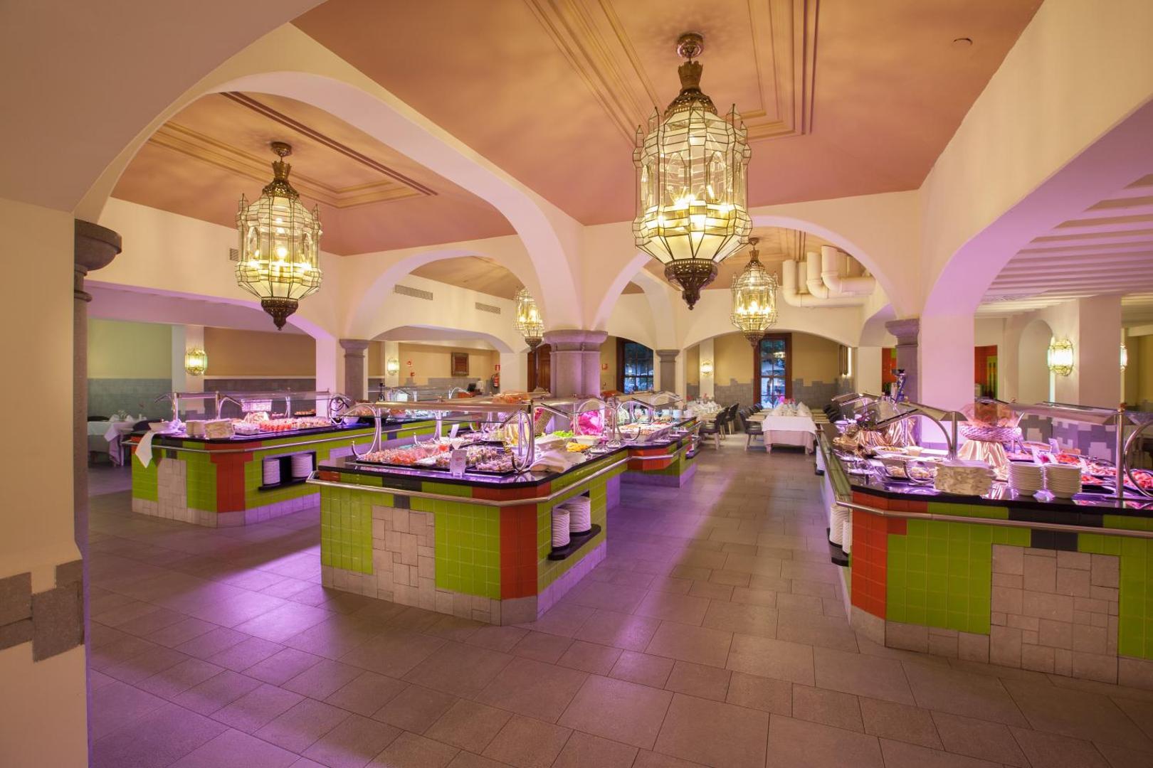 Lopesan Villa del Conde Resort & Thalasso bufetes tipa restorāns ar krāšņām lustrām un plašu ēdienu izvēli viesnīcas viesiem