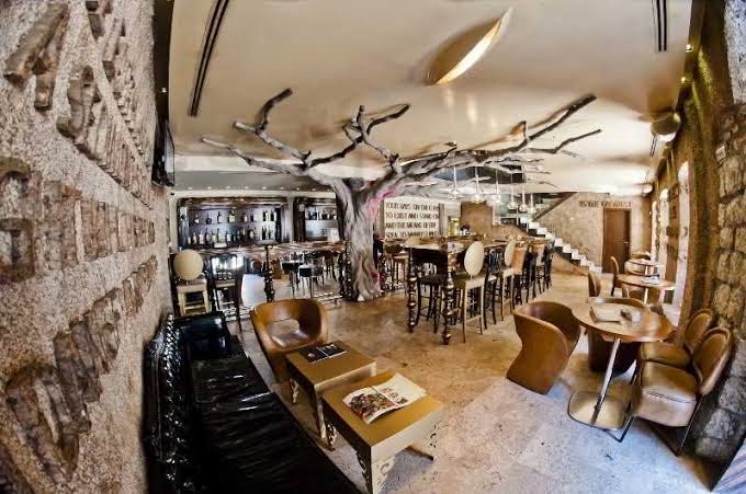 Astoria Boutique Hotel bārs un restorāns ar unikālu koka skulptūru centrā, dizaina mēbelēm un akmens apdari