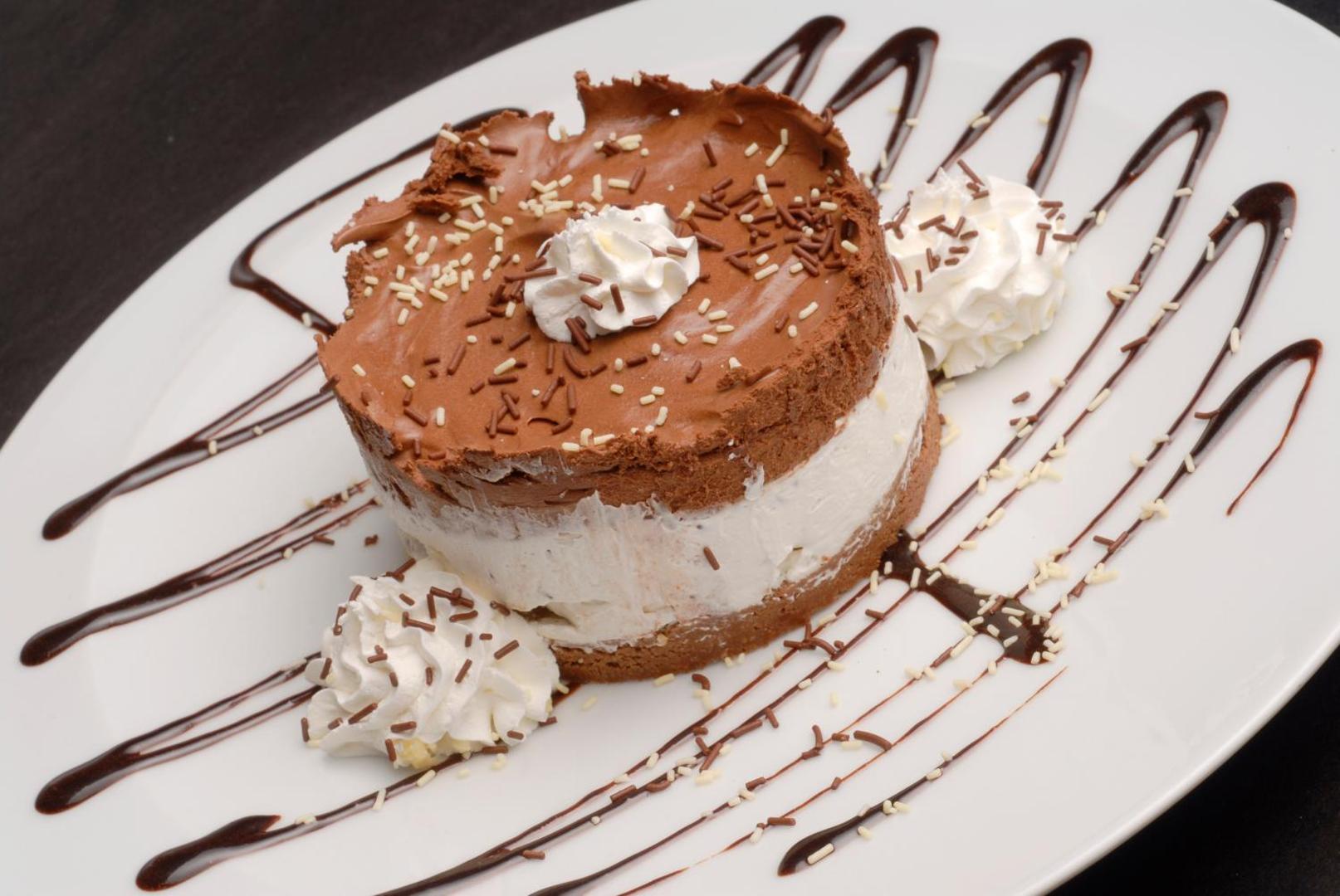 Kārtainais šokolādes un krēma deserts ar putukrējumu un mērci Astoria Boutique Hotel restorānā