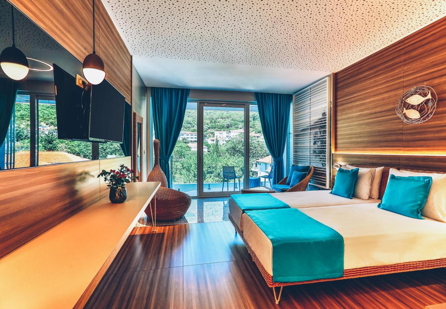 Carine Hotel Kumbor divvietīgs numurs ar atsevišķām gultām, lielu TV un panorāmas logiem uz dārzu un kalniem Kumborā