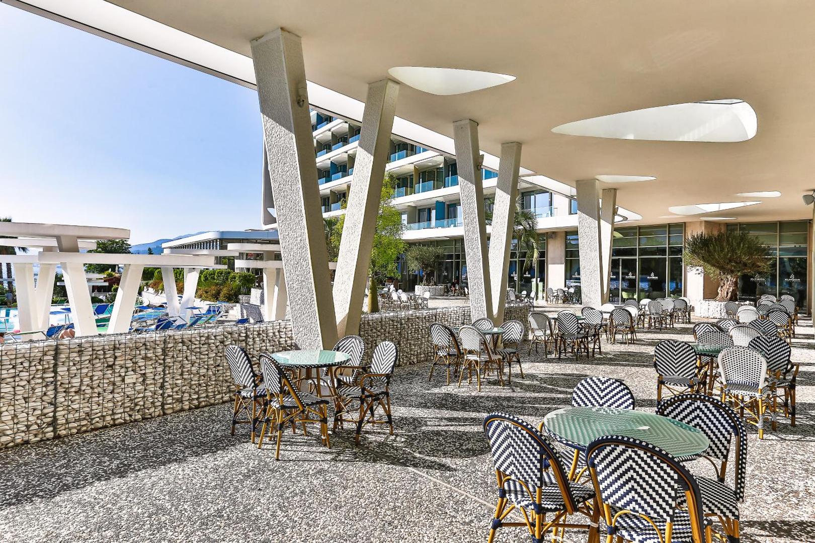 Carine Hotel Kumbor Superior āra restorāna terase ar modernām mēbelēm, nojumi un skatu uz viesnīcas teritoriju
