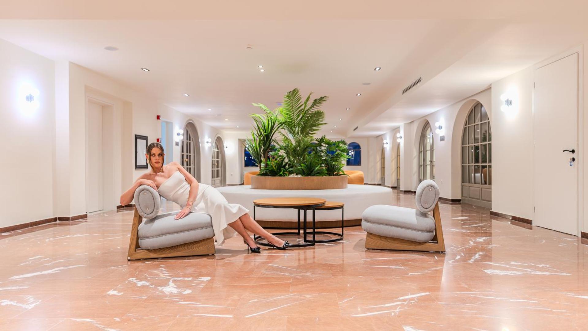 Iolida Corfu Resort & Spa lobby atpūtas zona ar moderniem krēsliem, marmora grīdu un zaļiem augiem centrā
