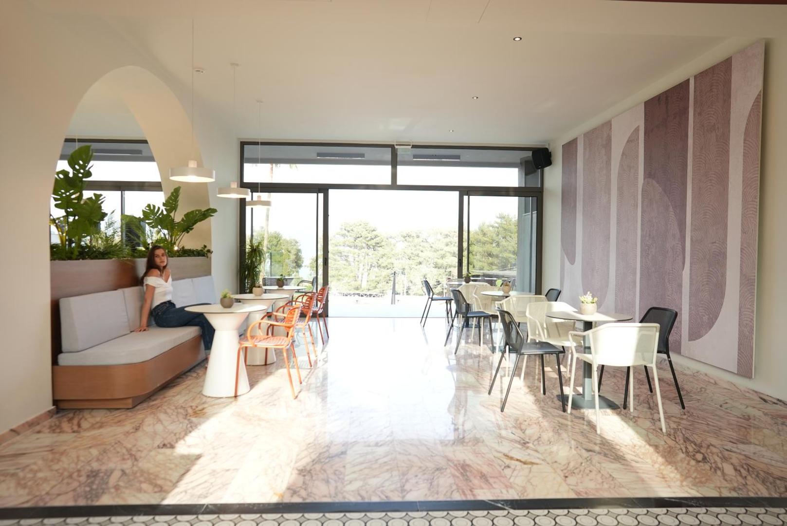 Iolida Corfu Resort & Spa gaišs vestibils ar atpūtas zonu, marmora grīdām un modernām mēbelēm Korfu salā, Grieķijā