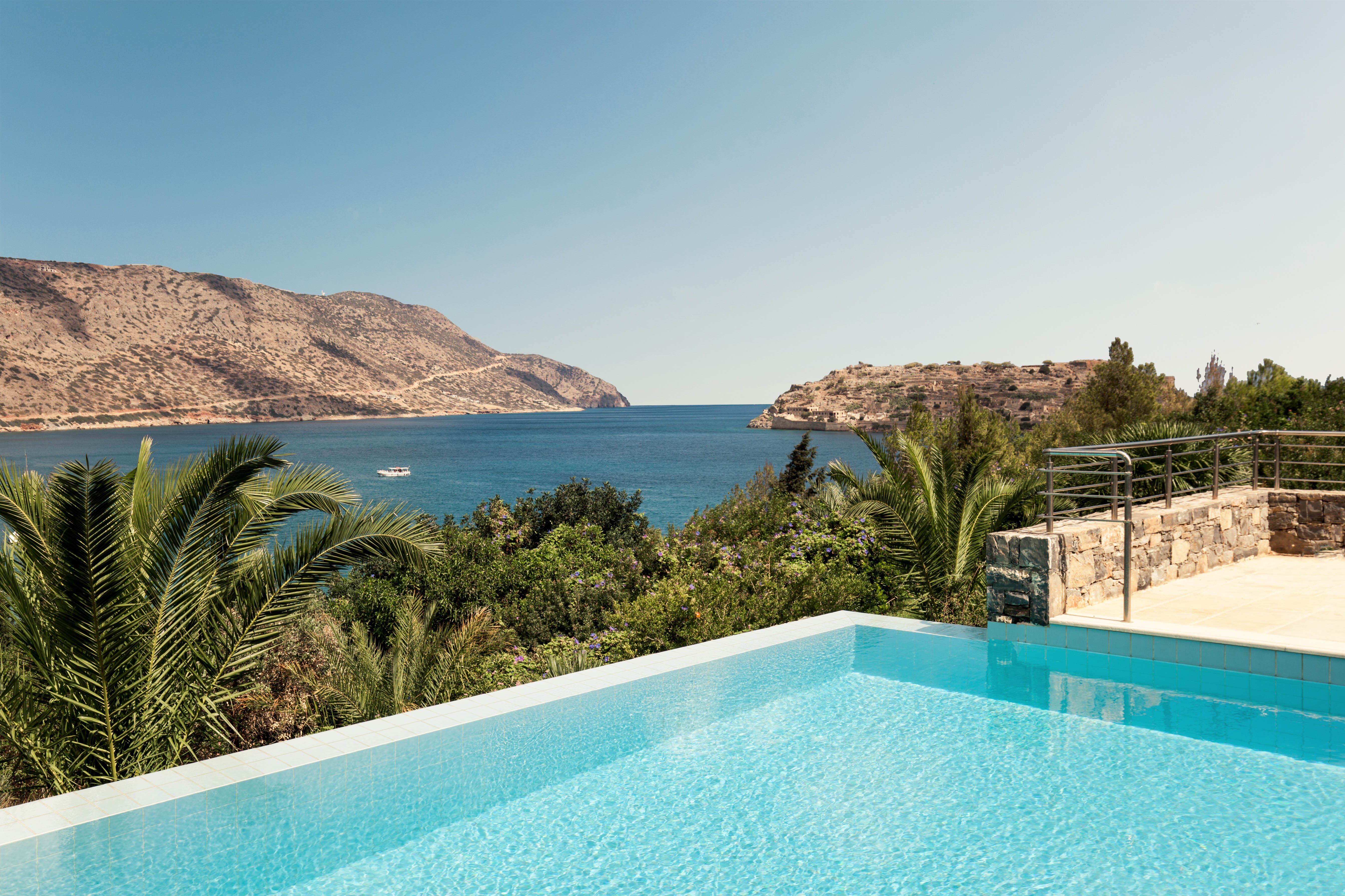 Skats uz baseinu un jūru ar kalniem fonā panoramic view with beach and pools