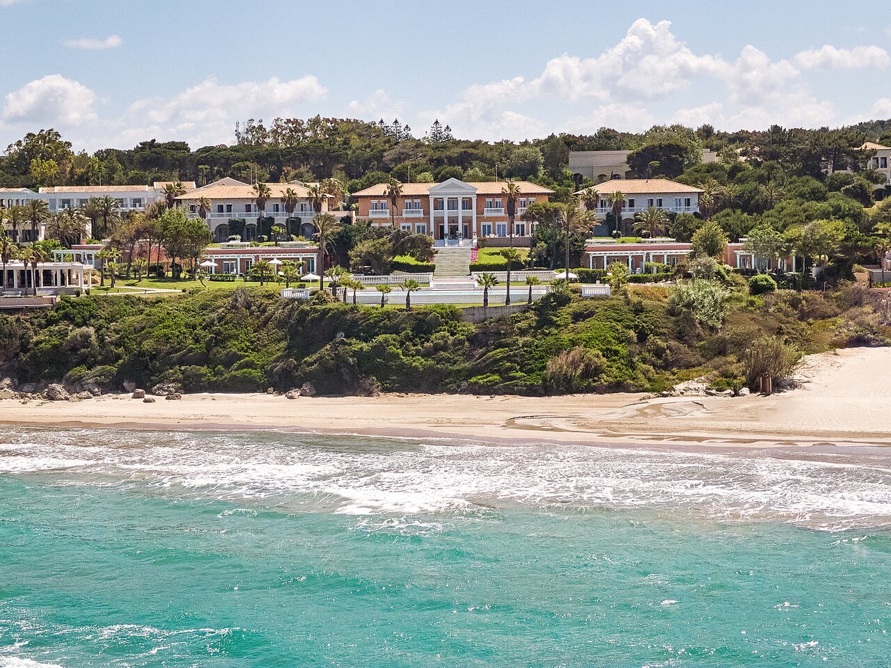 Grezna piekrastes villa ar plašu dārzu un palmām, kas atrodas blakus smilšu pludmalei un zilām jūras viļņiem. Ideāla vieta relaksācijai un atpūtai. panoramic view with beach and pools