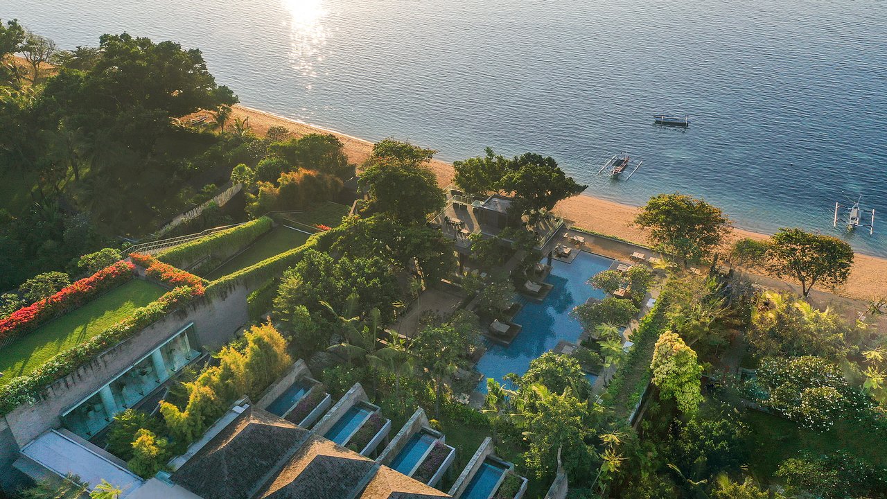 Piejūras kūrorts ar zilu baseinu un zaļām ainavām, kas piedāvā relaksējošu atmosfēru un skaistus skatus uz okeānu. panoramic view with beach and pools