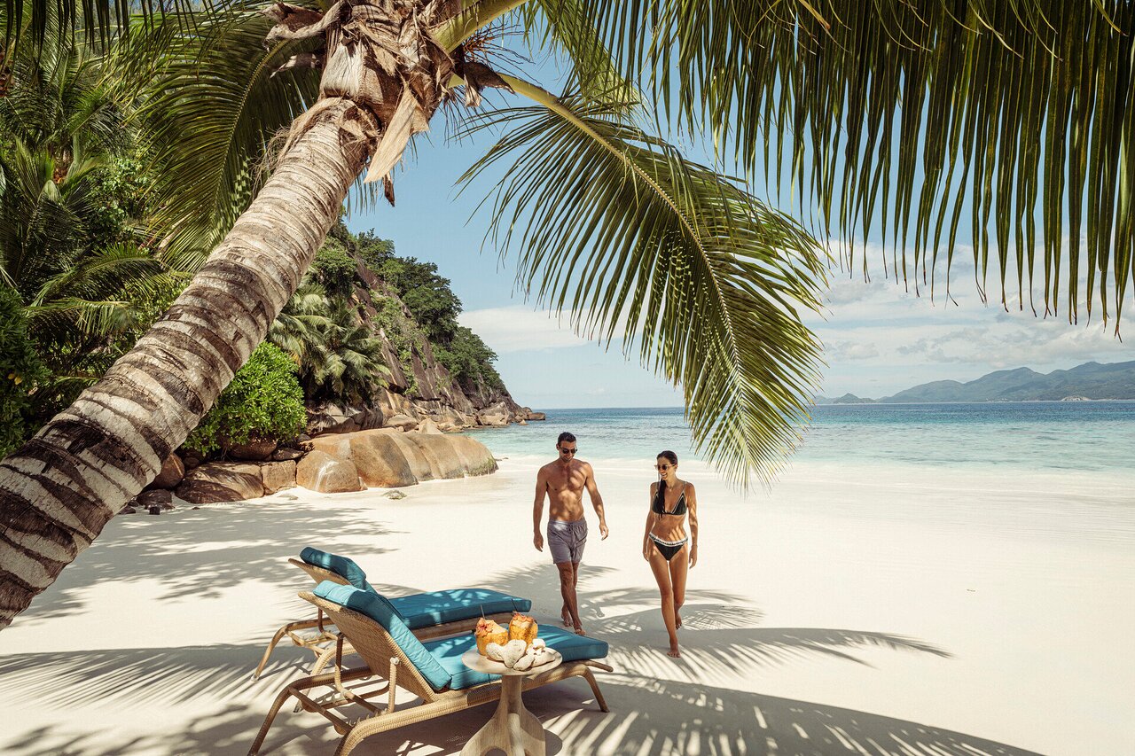Pāris bauda saulainu dienu Four Seasons Resort Seychelles privātajā pludmalē.