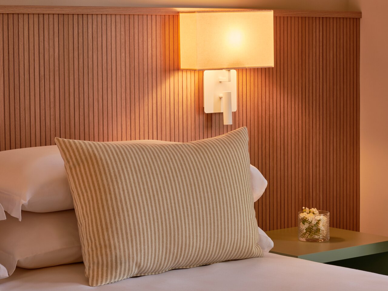 Serene Resort viesnīcas numurs ar elegantām lampām un spilvenu.