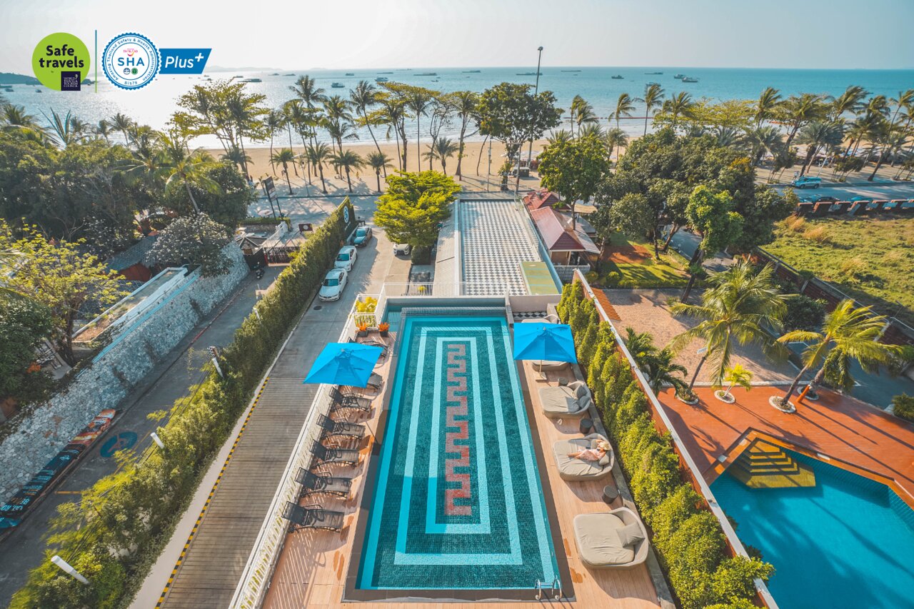 Viesnīcas baseins ar zilu jumtu un modernu flīžu dizainu, blakus pludmalei un palmām, radot relaksējošu atmosfēru. Skats uz jūru un apkārtējo dabu. panoramic view with beach and pools