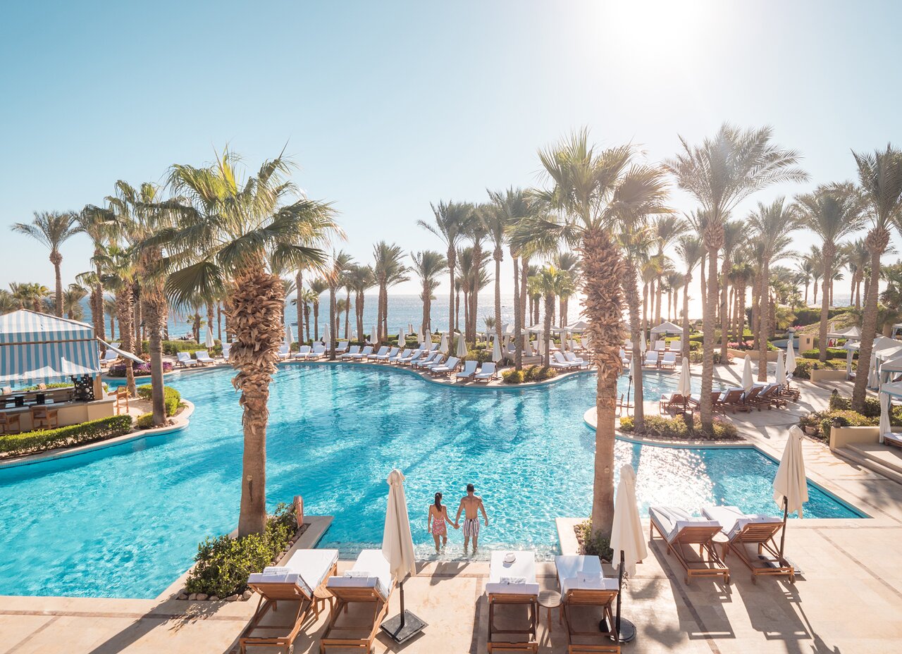 Four Seasons Resort Sharm El Sheikh plašais āra baseins ar palmām un skatu uz jūru