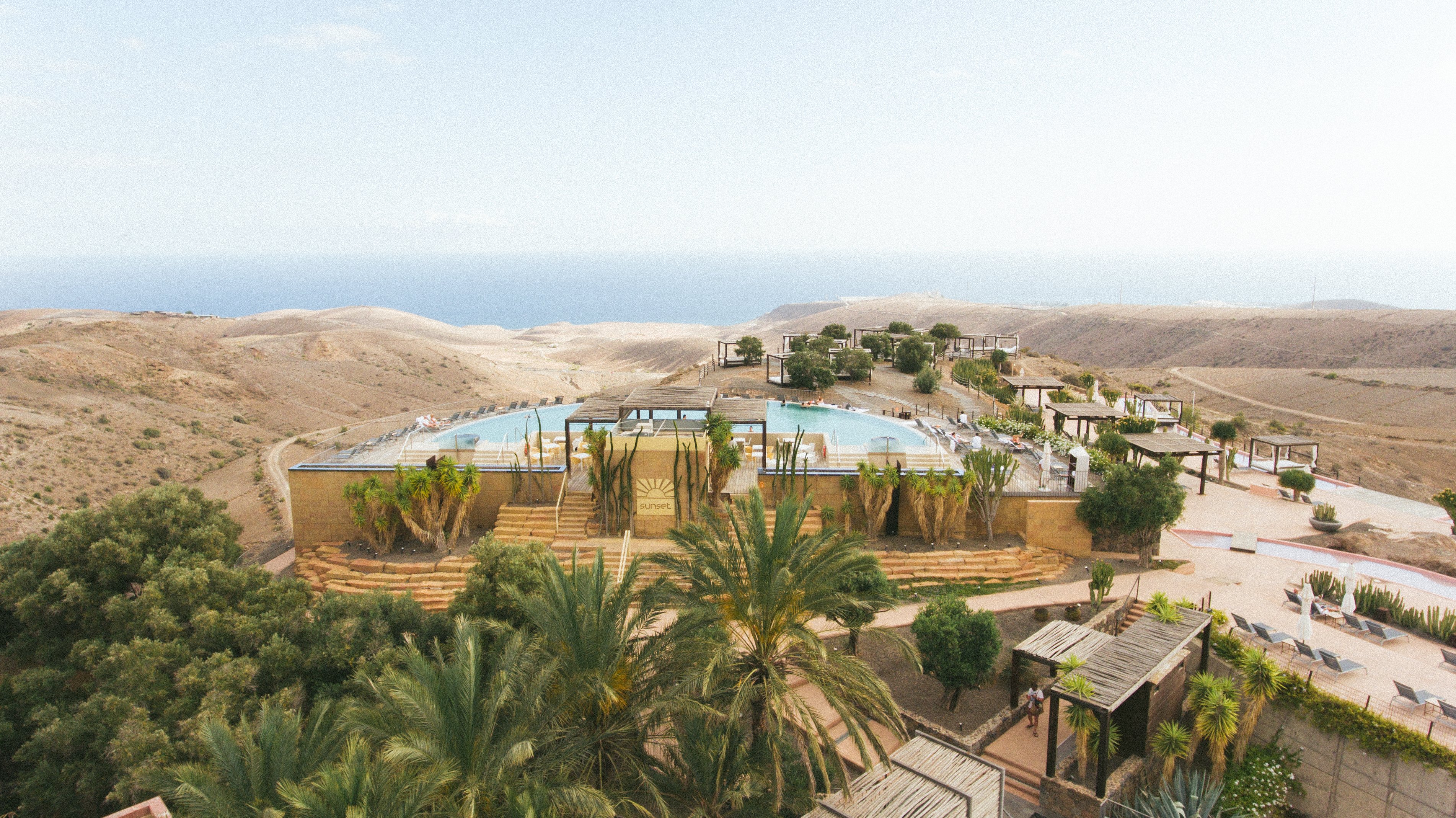Mūsdienīgs kūrorts ar baseiniem un ainavisku skatu uz jūru, ieskauts kalnu ainavā. Ideāla vieta atpūtai un relaksācijai. panoramic view with beach and pools