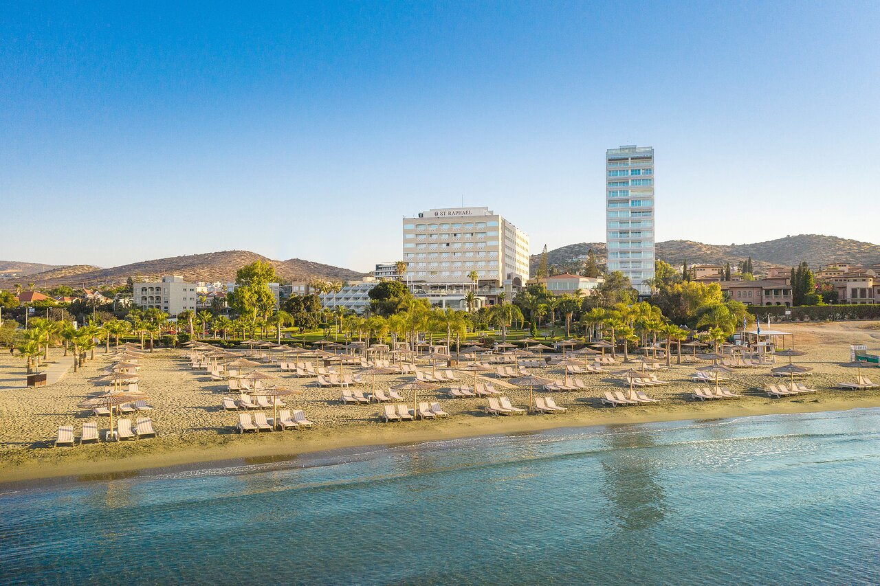 Pludmale ar saulessargiem un viesnīcām, skats uz kalniem un skaidru debesi. Ideāla vieta atpūtai un relaksācijai pie ūdens. panoramic view with beach and pools