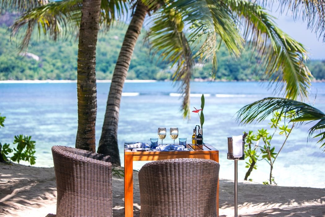 Romantisks galdiņa klājums pludmalē Kempinski Seychelles Resort ar skatu uz okeānu